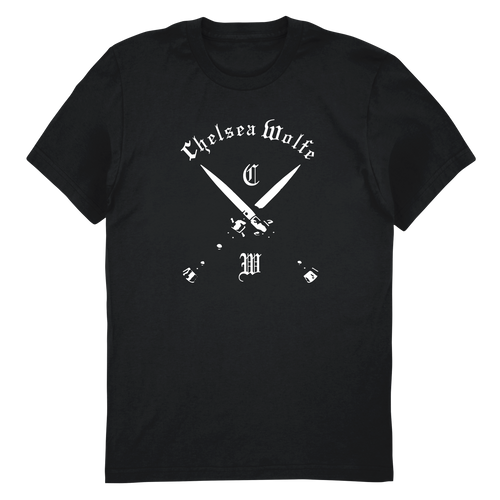A black short-sleeve crewneck t-shirt with a white graphic on the front featuring the text 'Chelsen Wolfe' in a gothic font above two crossed swords and the letters 'C' and 'M'.